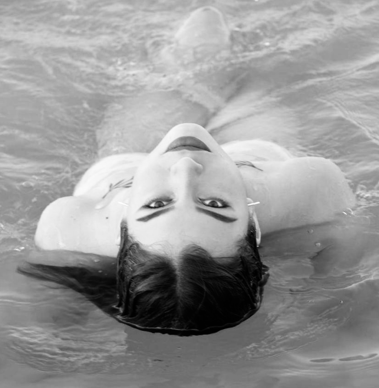 Retrato artístico en blanco y negro flotando en el agua